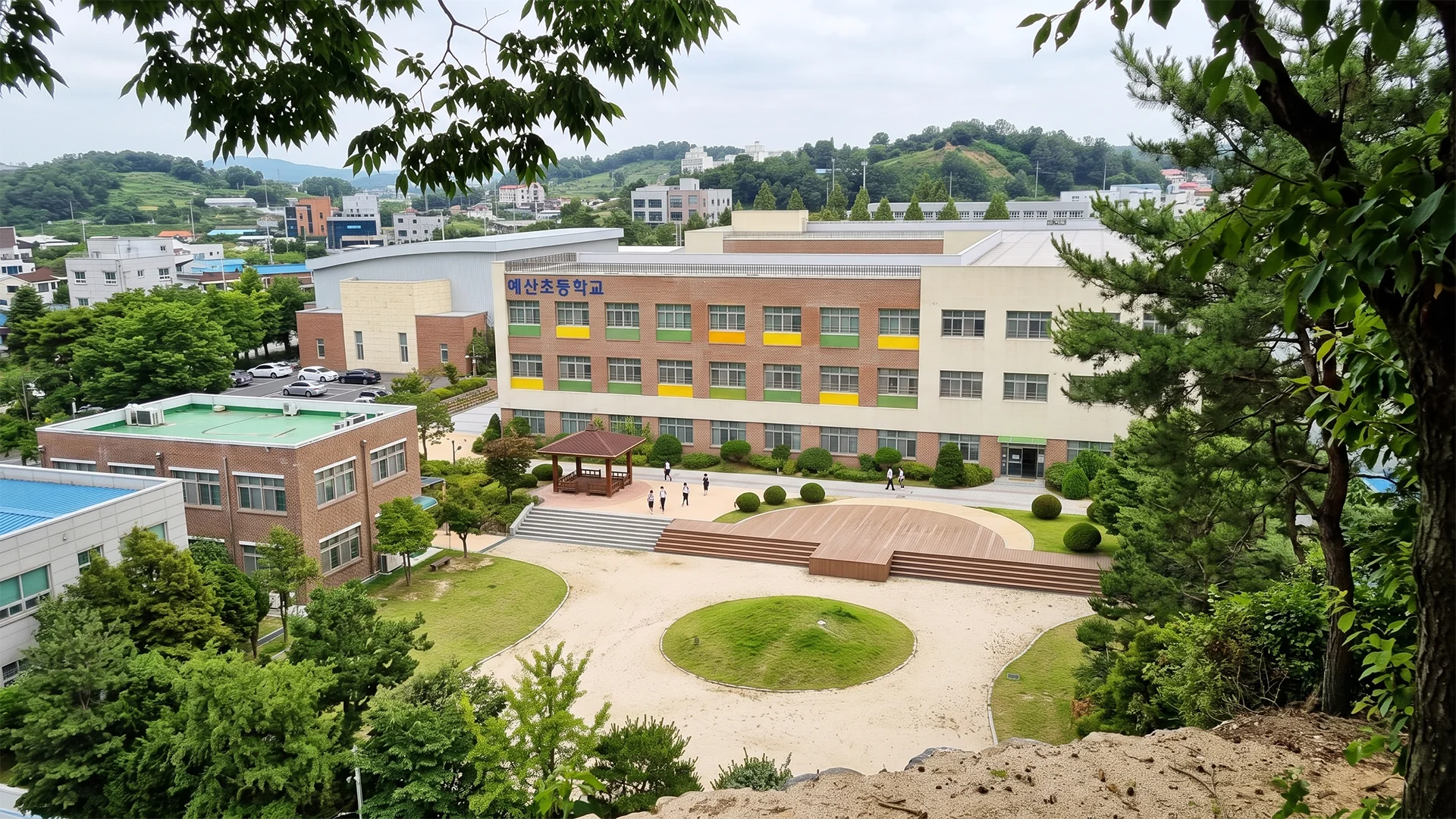 예산초등학교의 학교 건물과 운동장, 야외 무대 및 녹지 공간을 표현한 학교시설 건축 조감도